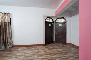 two brown doors in a room with white walls at SPOT ON Hotel prayag villa in Allahābād
