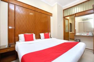 a bedroom with a large bed with red and white pillows at Hotel O Basera Boutique in Amritsar