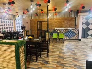 Un comedor con mesas y sillas verdes. en Hotel Urban Nest, en Noida