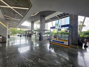 an empty lobby of a building with a ticket counter at Strategic Pacific Gardenia studio Alam Sutra pool and Gym by Luckystay in Warungnangka +38 photos