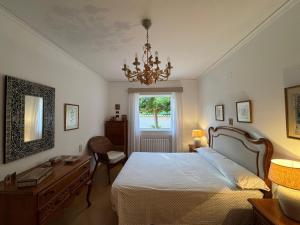a bedroom with a bed and a desk and a chandelier at Agradable Villa junto al mar con piscina in Sagunto
