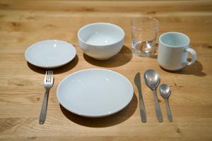 a table with plates and utensils and a glass at Grand Success Kotoni V in Kotoni