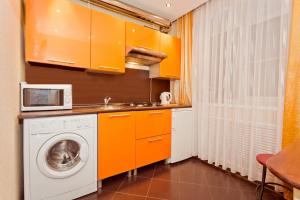 ニジニ・ノヴゴロドにある5days-nn, 2 bedroom Apartment on Dolzhanskaya, 8のキッチン(オレンジ色のキャビネット、洗濯機付)