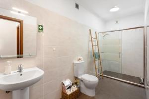 a bathroom with a toilet and a sink and a shower at Blissful Haven - Soulful Stays in Ilhéu Mole