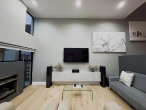 a living room with a couch and a tv at Birdsong Apartment in Oubaai Golf Estate in Herolds Bay