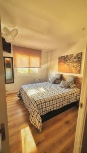 a bedroom with a bed with a checkered blanket at Habitación premium in Vilanova i la Geltrú