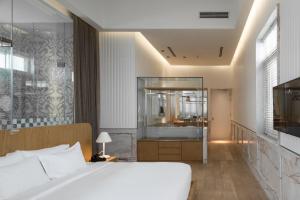 a bedroom with a large bed and a bathroom at Macalister Mansion, a Member of Design Hotels in George Town