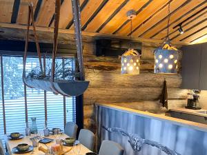 a dining room with a table with chairs and lights at Holiday Villa Karhunkelo - sis 4 kpl hissilippuja in Ukkohalla