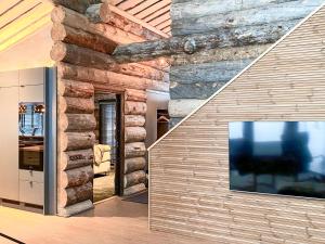 a living room with a stone wall and a large window at Holiday Villa Karhunkelo - sis 4 kpl hissilippuja in Ukkohalla