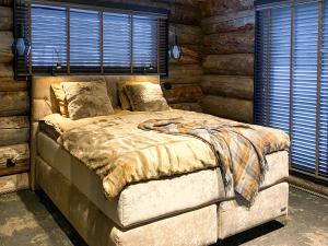 a bedroom with a large bed in a log cabin at Holiday Villa Karhunkelo - sis 4 kpl hissilippuja in Ukkohalla
