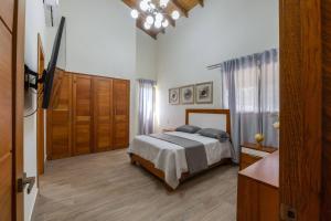 a bedroom with a bed and a dresser and a door at La Vega Villa with Private Pool and BBQ in Santo Cerro +24 photos