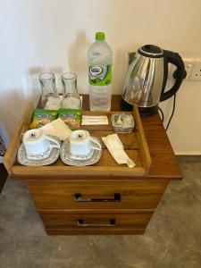 a wooden table with cups and plates and a coffee maker at Surf Heavens in Dickwella