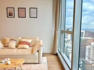 a living room with a couch and a large window at Luxury High-Rise Ocean View Perfect Stay at WSP in Melbourne