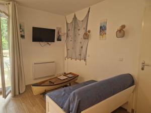 ein Schlafzimmer mit einem Bett und einem Tisch und einem Fernseher in der Unterkunft Appartement pour 4 à 6 personnes avec piscine in Le Verdon-sur-Mer