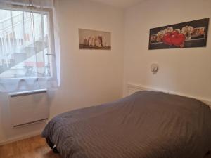 ein Schlafzimmer mit einem Bett und einem Fenster in der Unterkunft Appartement pour 4 à 6 personnes avec piscine in Le Verdon-sur-Mer