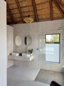 Un baño con dos lavabos y un espejo. en Pezulu Lodge, en Bela-Bela 25 fotos más