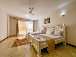 a bedroom with two beds and a window at Eliana's nyali 3 min to the beach homes in Mombasa +19 photos