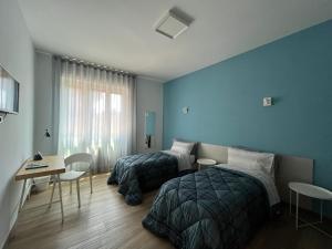 a bedroom with two beds and a desk and a table at Dimora in Fiore B&B in Foggia