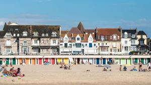 a group of people on a beach in front of buildings at Appartement plein centre à 300m de la plage in Le Touquet-Paris-Plage