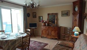 a living room with a table and a television at Appartement plein centre à 300m de la plage in Le Touquet-Paris-Plage
