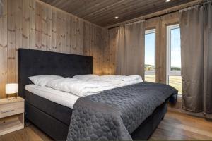 un grande letto in una camera da letto con pareti in legno di Koselig leilighet med ski in ski out på Golsfjellet a Gol