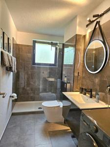 a bathroom with a toilet and a sink and a shower at Ferienwohnung Arquitecto Talblick mit Balkon - Mein SWH in Todtmoos