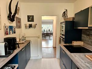 a kitchen with blue cabinets and a counter top at Ferienwohnung Arquitecto Talblick mit Balkon - Mein SWH in Todtmoos +12 photos