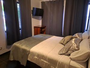 a bedroom with a bed and a television in a room at Costa Verde Retreat 1 - Ground Floor in Quepos