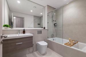 a bathroom with a toilet and a sink and a bath tub at F1 Chic Yas Studio Park Discounts! Near Yas Golf in Yas Island