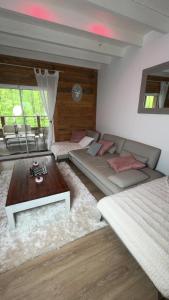 ein Wohnzimmer mit einer Couch und einem Couchtisch in der Unterkunft Cottage de Pénélope in Lunéville