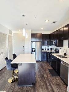 a kitchen with a white counter top and wooden cabinets at Central Frisco Vibes 1 BR Apart With POOL & GYM in Frisco