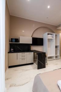 a kitchen with white cabinets and a black counter top at Al Giordano in Piazza in Foggia