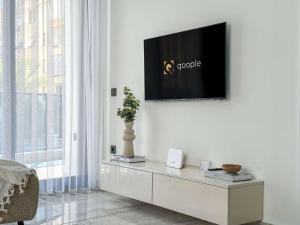 a living room with a tv on a white wall at Qoople Aria premium apartments in the center of Alanya in Alanya