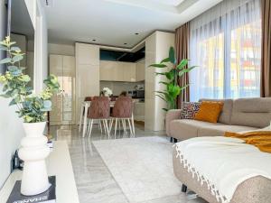 a living room with a couch and a table at Qoople Aria premium apartments in the center of Alanya in Alanya