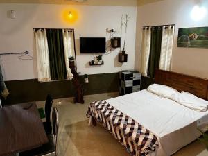 a bedroom with a bed and a flat screen tv at Dream Veedu Home Stay Banasura in Padinjarathara