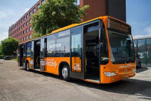 an orange bus parked on the side of a street at Bastion Hotel Amsterdam Airport in Hoofddorp
