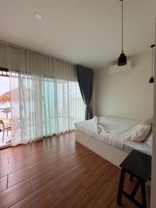 a bedroom with a bed and a large window at Chansi Beachresort in Tha Sala +42 photos