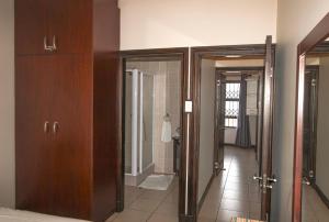 a bathroom with two open doors and a hallway at Topanga 52 in Uvongo Beach
