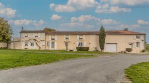 une grande maison avec une route devant elle dans l'établissement La maison d’eloi, à Montignac-Charente