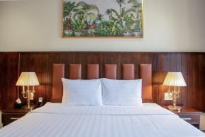 a bedroom with a large white bed with two lamps at Linh's Boutique Hotel in Phu Quoc