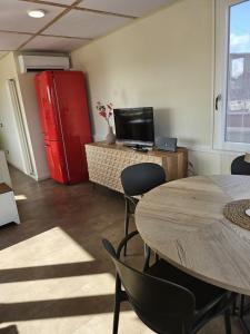 a room with two tables and a red refrigerator at La Terrazza in Rome