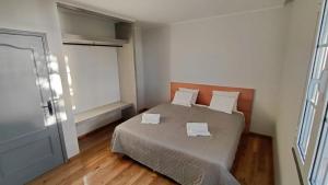 a bedroom with a bed with two towels on it at Oak Tree House- Ponta do Pargo in Lombada Velha
