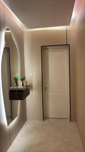 pasillo con puerta blanca y espejo en Jo studio, en Ar Ruqayyiqah 2 fotos más
