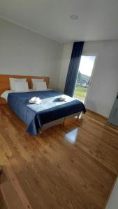 a bedroom with a bed and a large window at Oak Tree House- Ponta do Pargo in Lombada Velha