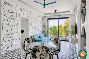 a living room with a glass table and chairs at The Blue Eyes by Leo Homes - 2BHK Flat in Candolim in Candolim