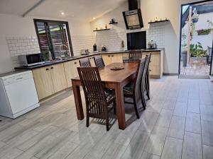 a kitchen with a wooden dining table and chairs at Ti KAZ MON SUZA in Saint-Philippe