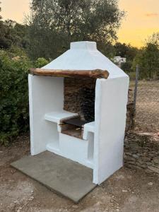 a white outdoor oven with stairs in a field at Casa Papiqui in Fuenteheridos