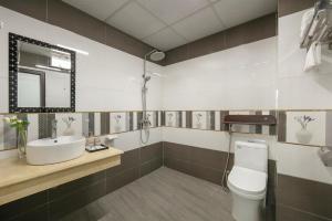 a bathroom with a sink and a toilet and a mirror at Royal Hotel & Spa Vinh Yen 2 in Háu Nữ