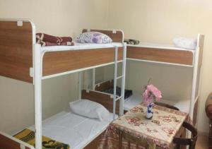 two bunk beds in a room with a table at Vila 1926 Entrepreneur in Polisi i Vogël