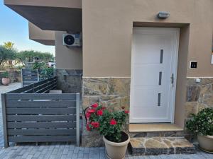 un edificio con una puerta y flores en ollas en Elounda Sunrise Apartments, en Elounda